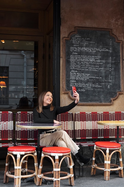 Vollschuss-Smiley-Frau, die Selfie nimmt