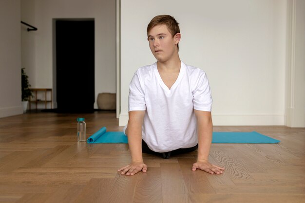 Vollschussjunge, der zu Hause Yoga macht