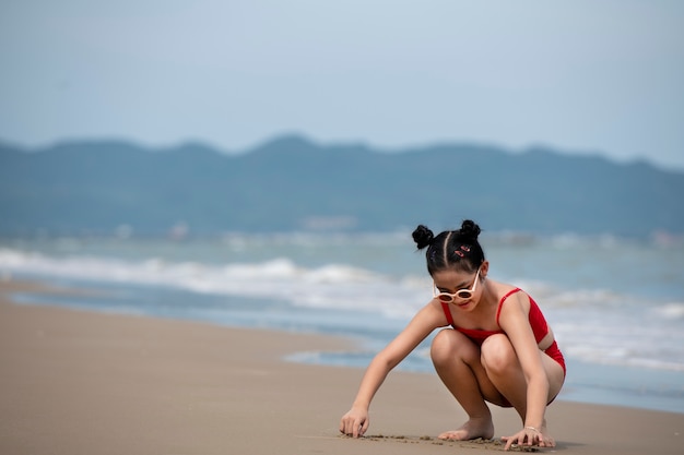 Kostenloses Foto vollschussmädchen, das am strand spielt