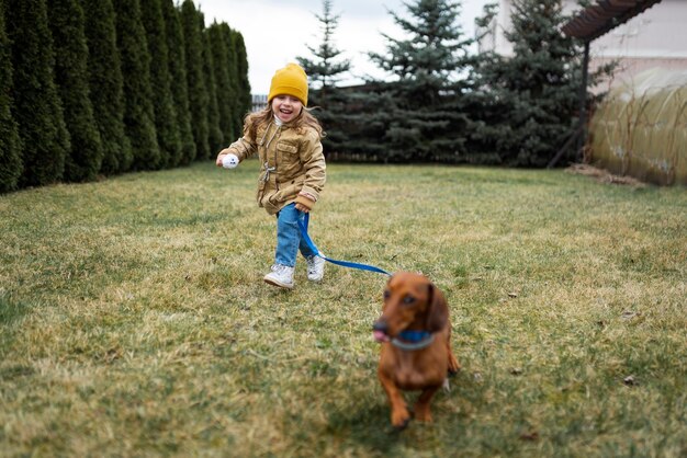 Vollschussmädchen, das draußen mit Hund spielt