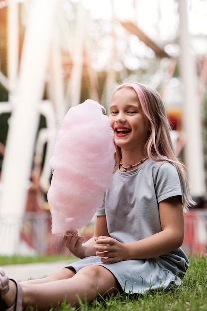 Kostenloses Foto vollschussmädchen, das zuckerwatte hält