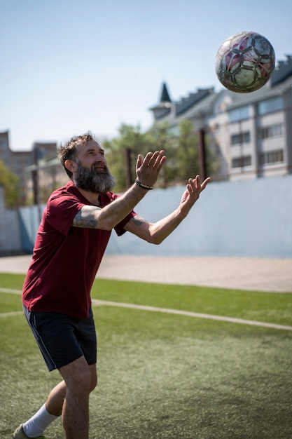 Kostenloses Foto vollschussmann, der fußball spielt