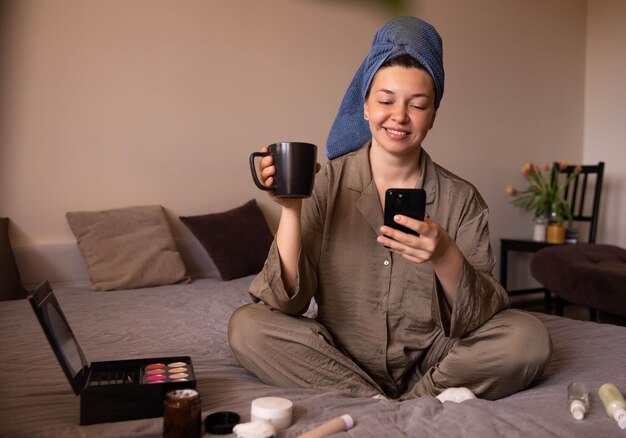 Vollständige Ansicht des frischen Frauenlächelns am Telefon mit einer Tasse Kaffee