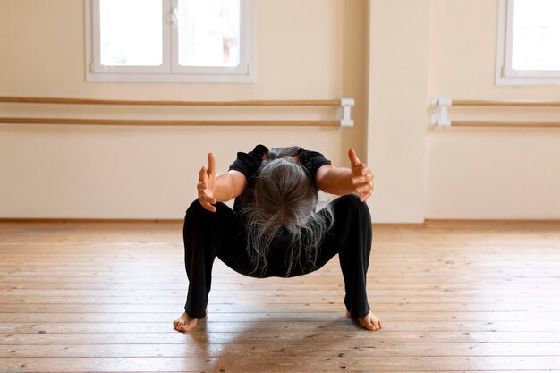 Vollständige Aufnahme einer älteren Frau, die im Studio tanzt