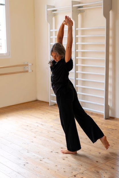 Vollständige Aufnahme einer älteren Frau, die im Studio tanzt
