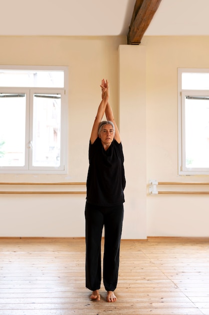 Vollständige Aufnahme einer älteren Frau, die im Studio tanzt