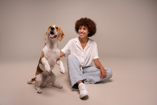 Kostenloses Foto vollständige aufnahme einer frau mit hund im studio