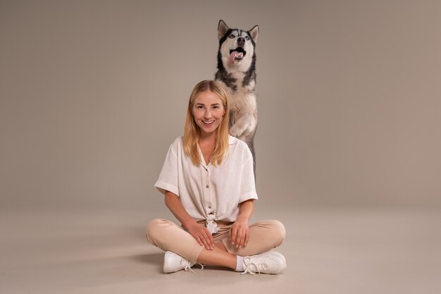 Vollständige Aufnahme einer Frau mit Hund im Studio