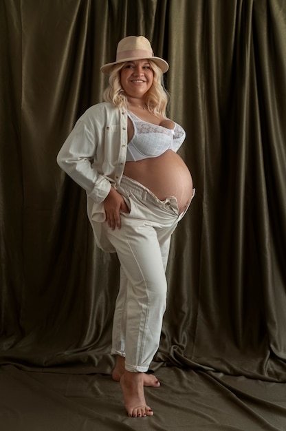 Vollständige Aufnahme einer schwangeren Frau, die im Studio posiert