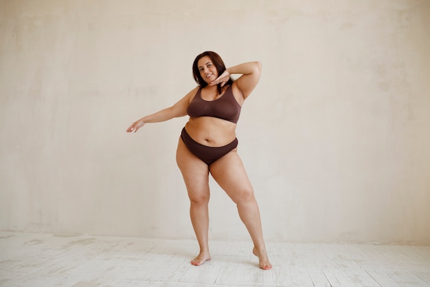 Vollständige Aufnahme eines Plus-Size-Models, das im Studio posiert