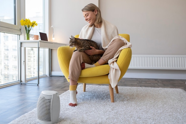 Vollständige Smiley-Frau, die mit Katze sitzt