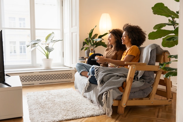 Vollständige Smiley-Frauen, die auf der Couch sitzen