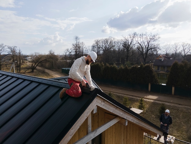 Vollständiger Dachdecker, der mit Helm arbeitet