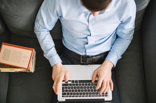 Vom oben genannten Mann, der Laptop auf Sofa verwendet