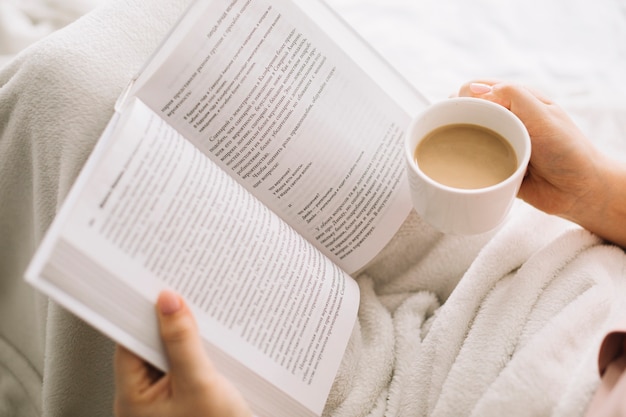 Von oben Frau mit Buch und Kaffee