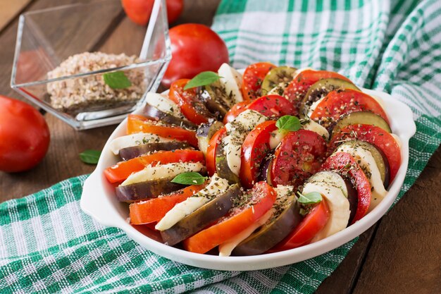 Vorbereitete Auflaufform rohe Auberginen mit Mozzarella und Tomaten