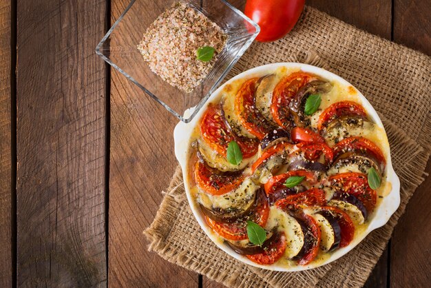 Vorbereitete Auflaufform rohe Auberginen mit Mozzarella und Tomaten
