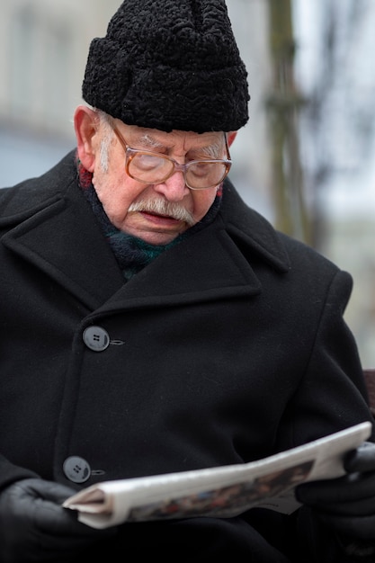 Kostenloses Foto vorderansicht älterer mann, der zeitung liest