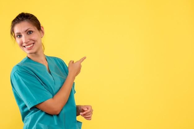 Kostenloses Foto vorderansicht-ärztin im medizinischen hemd auf gelbem hintergrund