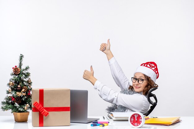 Vorderansicht Arbeiterin sitzt vor ihrem Arbeitsplatz lächelnd Büroarbeit Business Weihnachtsjob