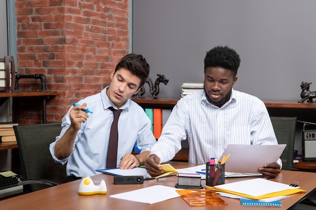 Vorderansicht-Arbeitsprozess zwei Geschäftsleute, die in einem modernen Büro arbeiten