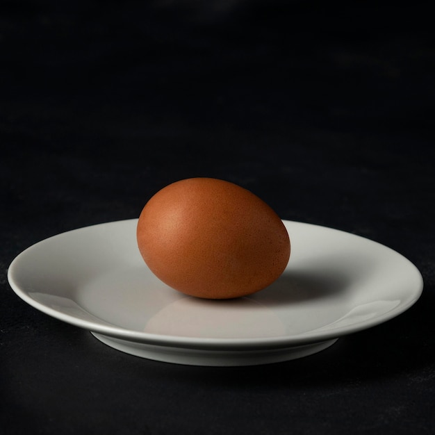 Vorderansicht braunes Ei auf Teller