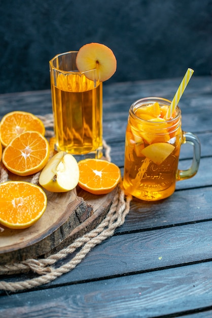 Vorderansicht Cocktail geschnittene Orangen und Äpfel auf Holzbrett auf dunkel