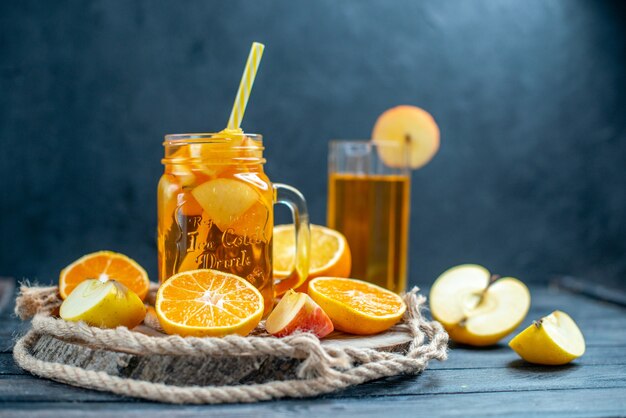 Vorderansicht Cocktail geschnittene Orangen und Äpfel auf Holzbrett auf dunkel