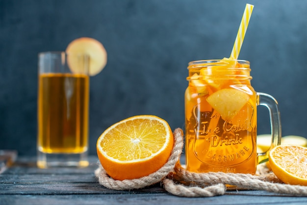 Vorderansicht Cocktail geschnittene Orangen und Äpfel auf Holzbrett auf dunkel