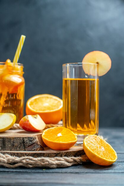 Vorderansicht Cocktail geschnittene Orangen und Äpfel auf Holzbrett auf dunklem, isoliertem Hintergrund