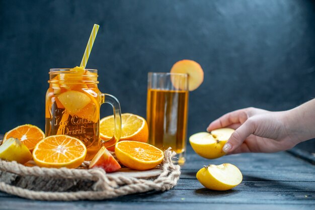 Vorderansicht Cocktail geschnittene Orangen und Äpfel auf Holzbrett auf dunklem, isoliertem Hintergrund