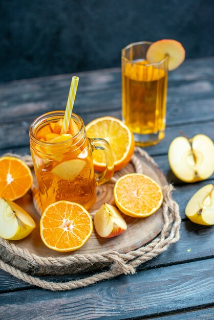 Vorderansicht Cocktail geschnittene Orangen und Äpfel auf Holzbrett auf dunklem, isoliertem Hintergrund