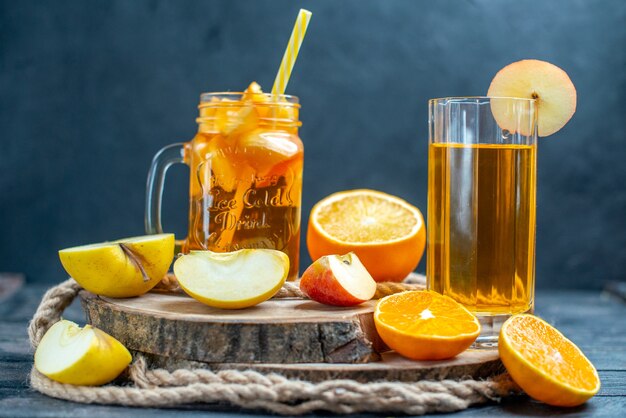 Vorderansicht Cocktail geschnittene Orangen und Äpfel auf Holzbrett auf dunklem, isoliertem Hintergrund