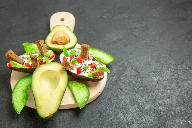 Vorderansicht cremige Avocados mit Brot und Pfeffer und frischen Avocados auf der Grauzone