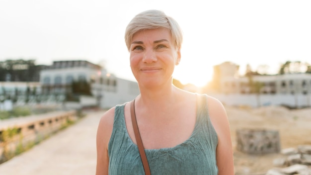 Kostenloses Foto vorderansicht der älteren touristenfrau am strand