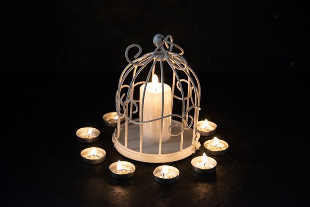 Vorderansicht der brennenden Kerze in der Lampe als Erinnerung für auf dunkle Oberfläche gefallen