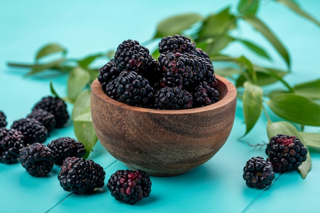 Vorderansicht der Brombeere in einer Holzschale auf einer hellblauen Oberfläche