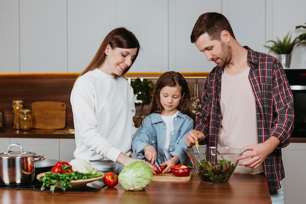 Vorderansicht der Familie, die Essen in der Küche zu Hause zubereitet