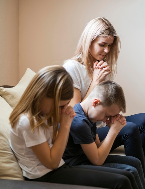 Kostenloses Foto vorderansicht der familie, die zu hause betet