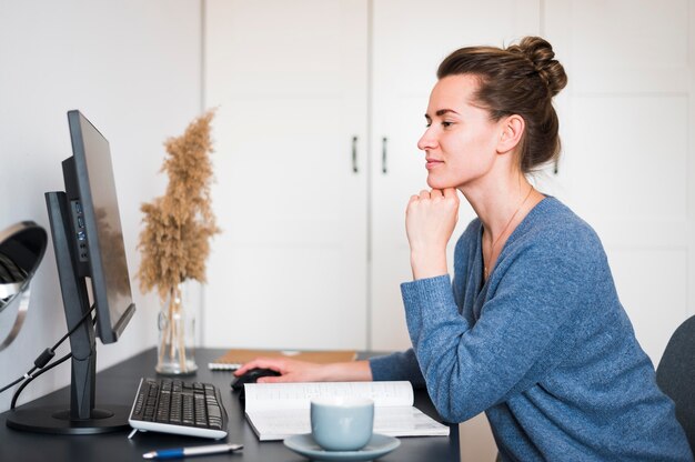 Vorderansicht der Frau, die am Schreibtisch arbeitet