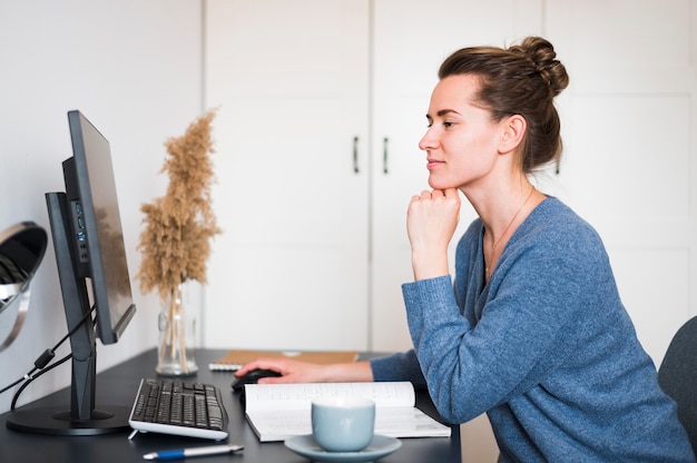 Vorderansicht der Frau, die am Schreibtisch arbeitet