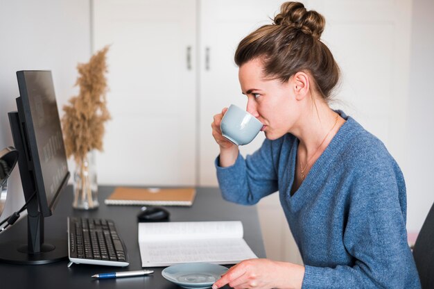 Vorderansicht der Frau, die am Schreibtisch arbeitet