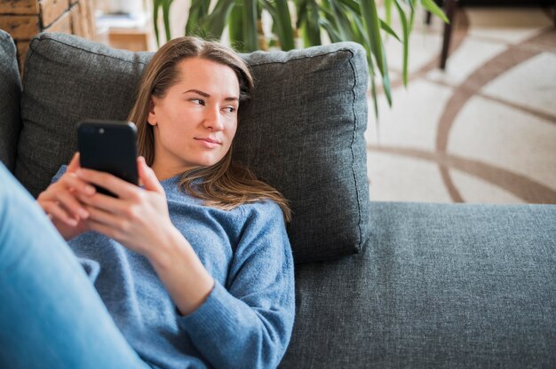 Vorderansicht der Frau, die auf Couch sitzt