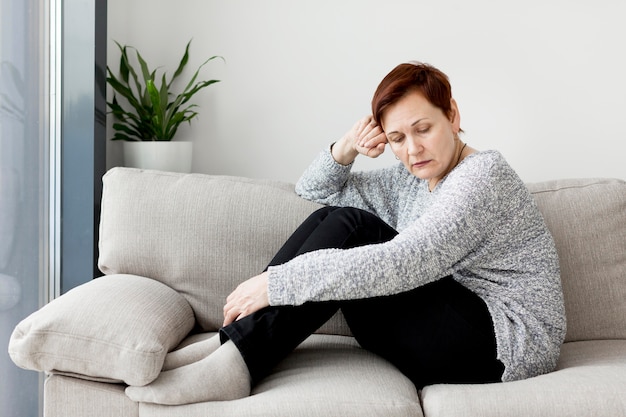 Vorderansicht der Frau, die auf Couch sitzt