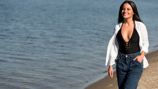 Vorderansicht der Frau, die auf dem Strand mit Kopienraum aufwirft