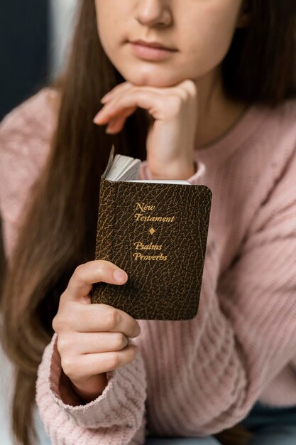 Vorderansicht der Frau, die das neue Testament liest