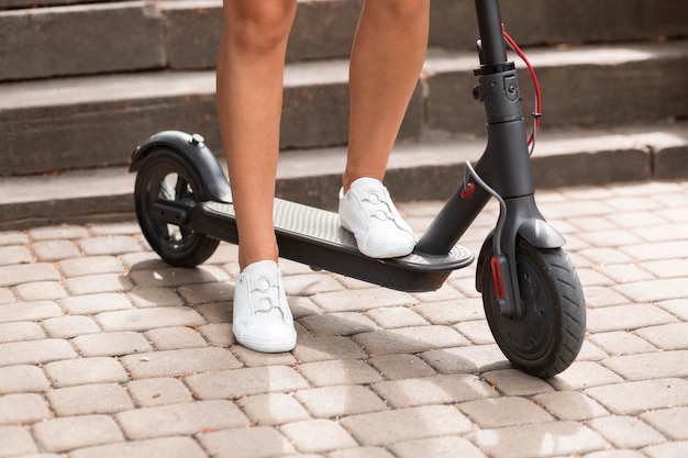 Vorderansicht der Frau, die Elektroroller reitet