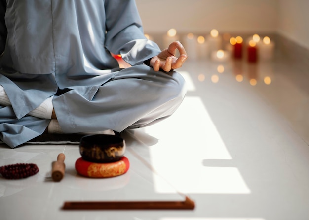 Kostenloses Foto vorderansicht der frau, die mit weihrauch und kerzen meditiert