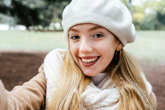 Vorderansicht der Frau, die selfie im Park während des Winters nimmt