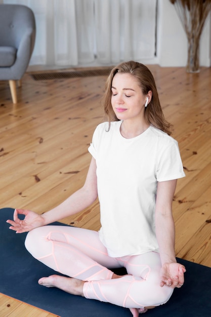 Kostenloses Foto vorderansicht der frau, die yoga zu hause tut